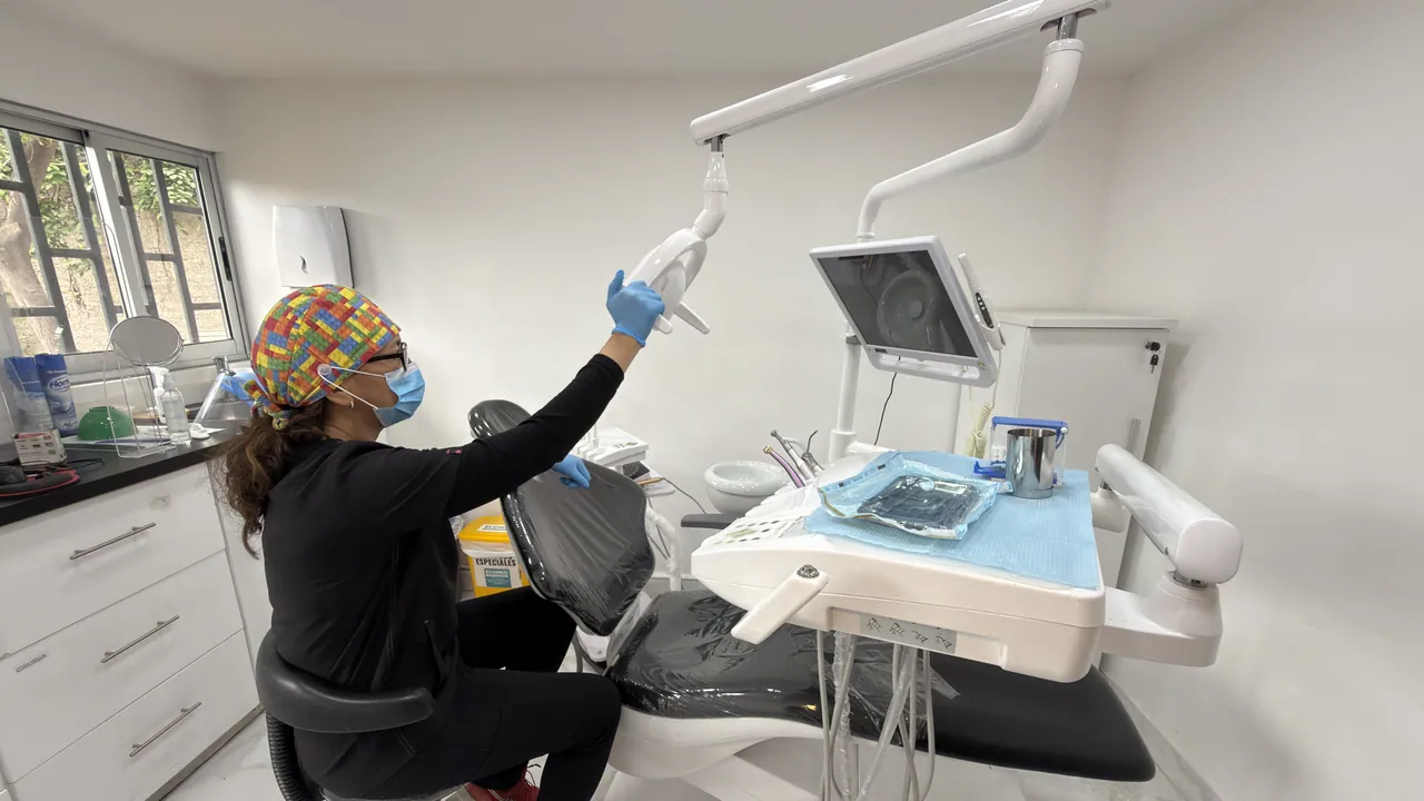 Profesional preparando el sillón y la lámpara en un box dental del Centro